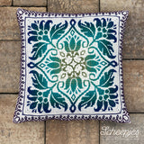 Decorative pillow with floral pattern on a wooden surface, featuring the brand 'Scheepjes'.